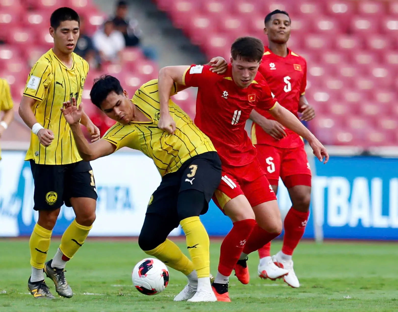 Malaysia (áo vàng) đánh bại Việt Nam 1-0 để giành huy chương đồng FIFA ASEAN Cup 2026